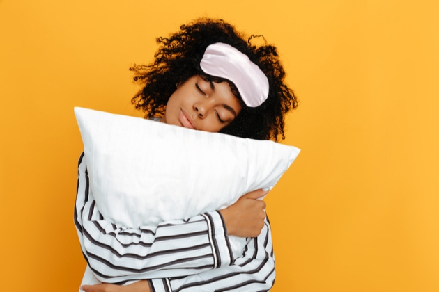 Lady in striped pajamas hugs white pillow