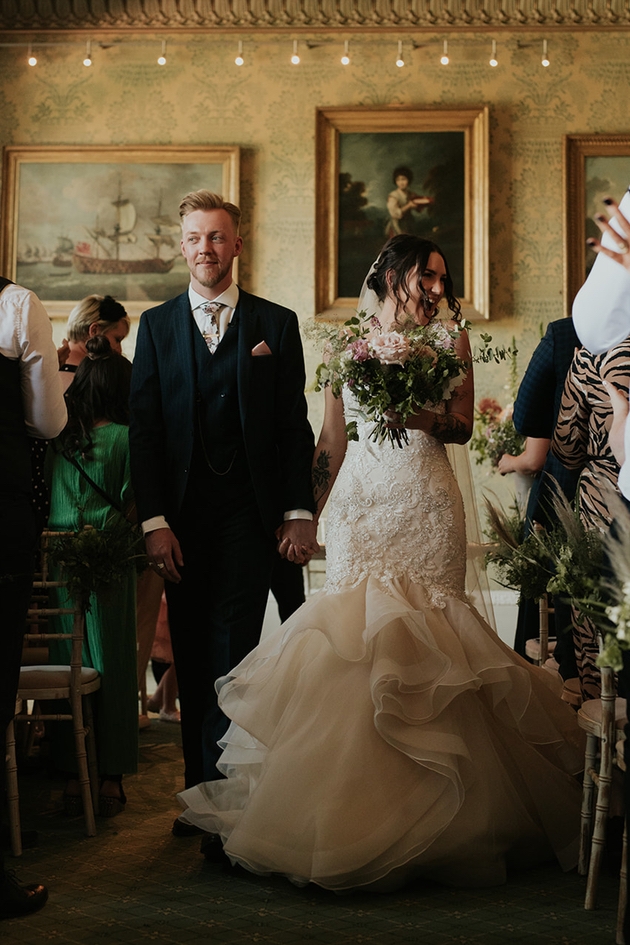 Couple walk through their guests after their wedding ceremony