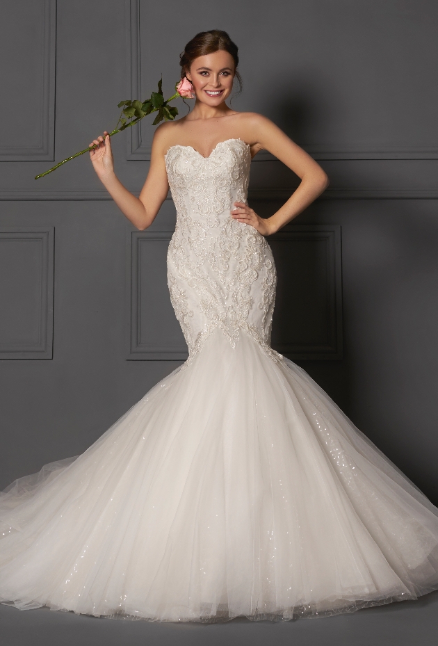 Bride wearing a Danielle Couture lace fishtail gown holding a rose