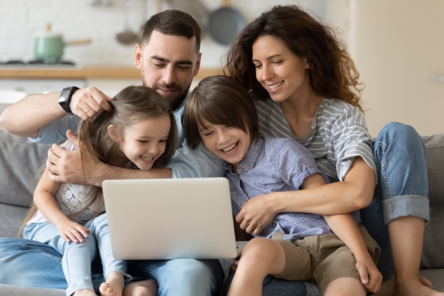 Couple with their kids looking at laptop