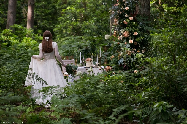 bride in woods walking to table set up