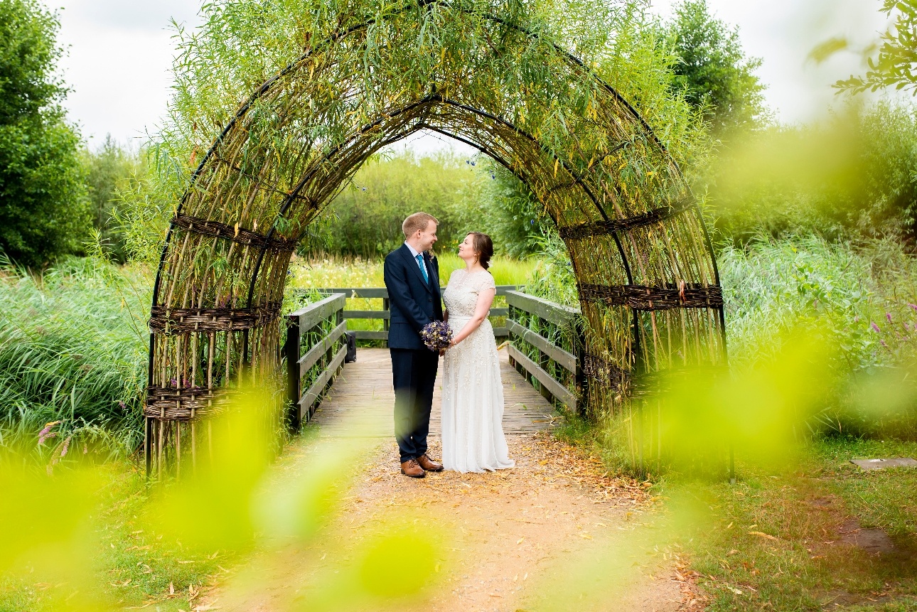 Couple pose under willow arch