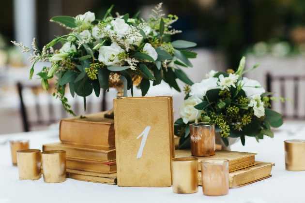 centerpiece of gold booked with flowers on top