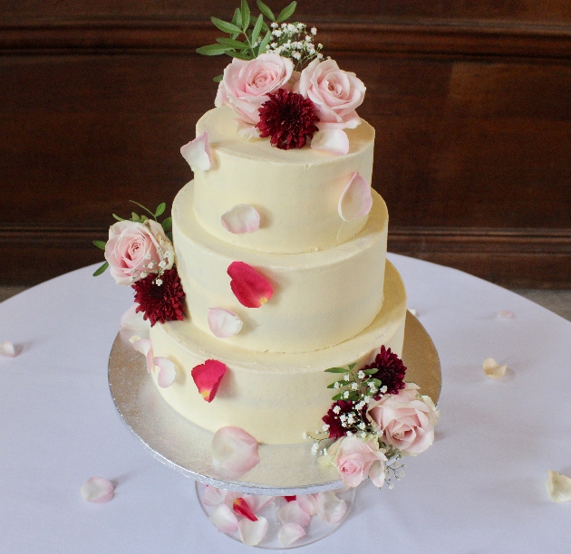 cream cake in three layers with real flowers on top
