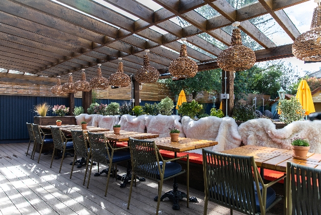 outdoor restaurant terraced with over head lighting an fur chair covers