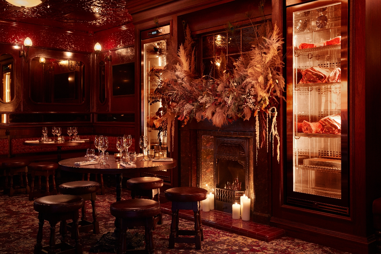 the rose room, red walls and ceiling, wood-panelled feature wall with fireplace