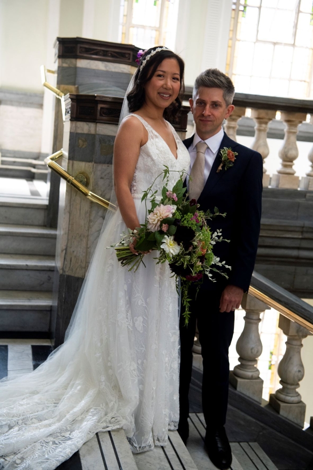 bride and groom standing on a marble staircase