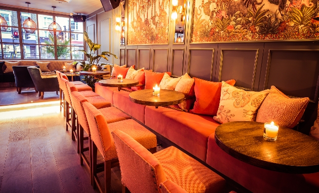 bar interior pastel peach velvet chairs panelled walls patterned wallpaper