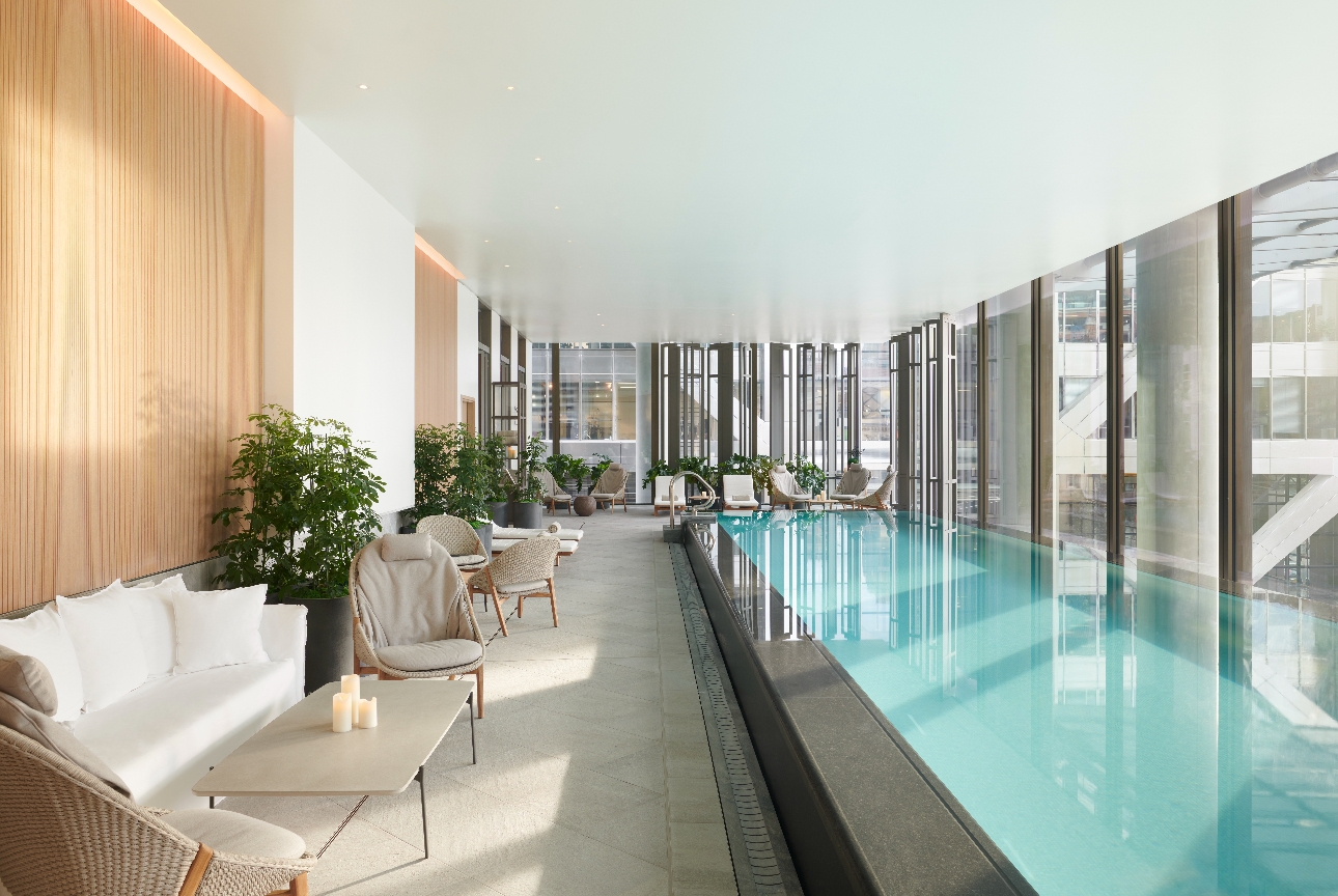 long pool with loungers running alongside it big glass windows