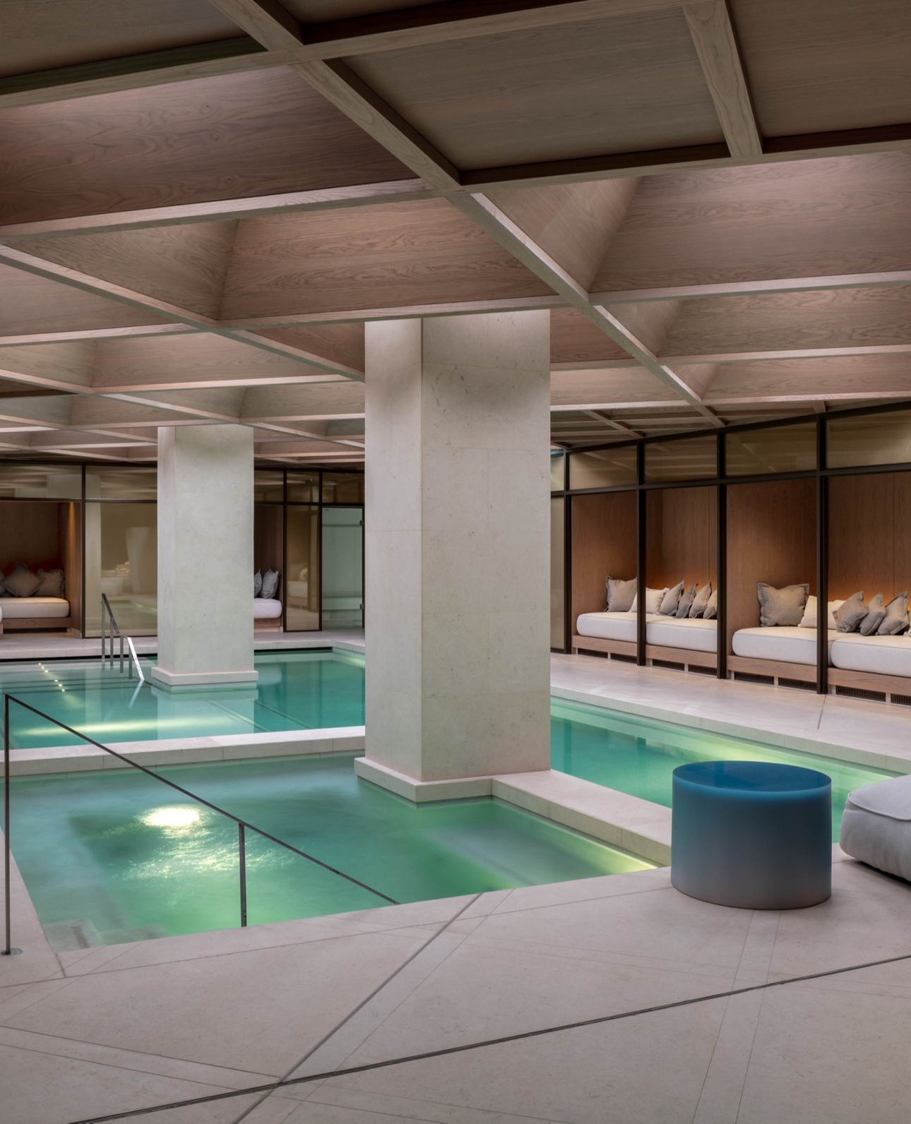 The Londoner's pool area with marble pillars and comfy seating areas