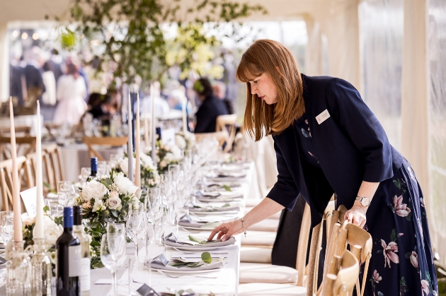 London wedding planner laying a table at a wedding reception