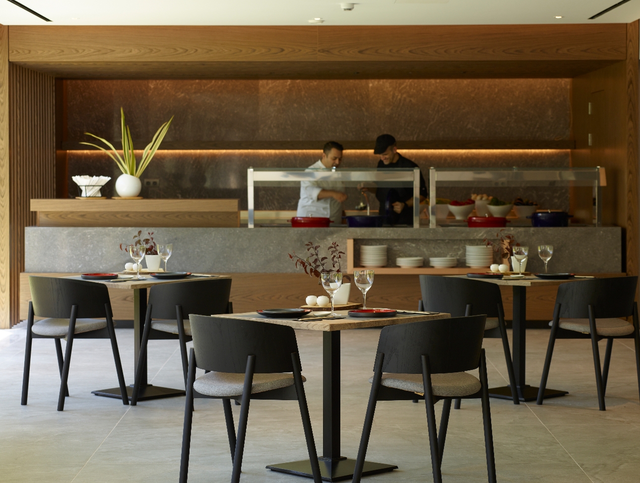 modern restuarant design stone floors small tables with black chairs