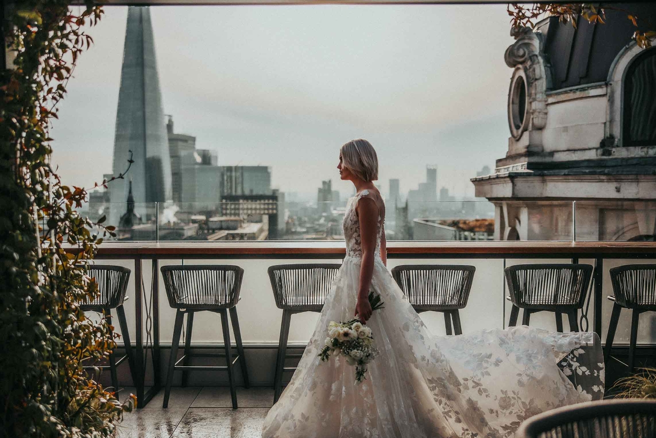 bride walking along roof terrace with london skyline