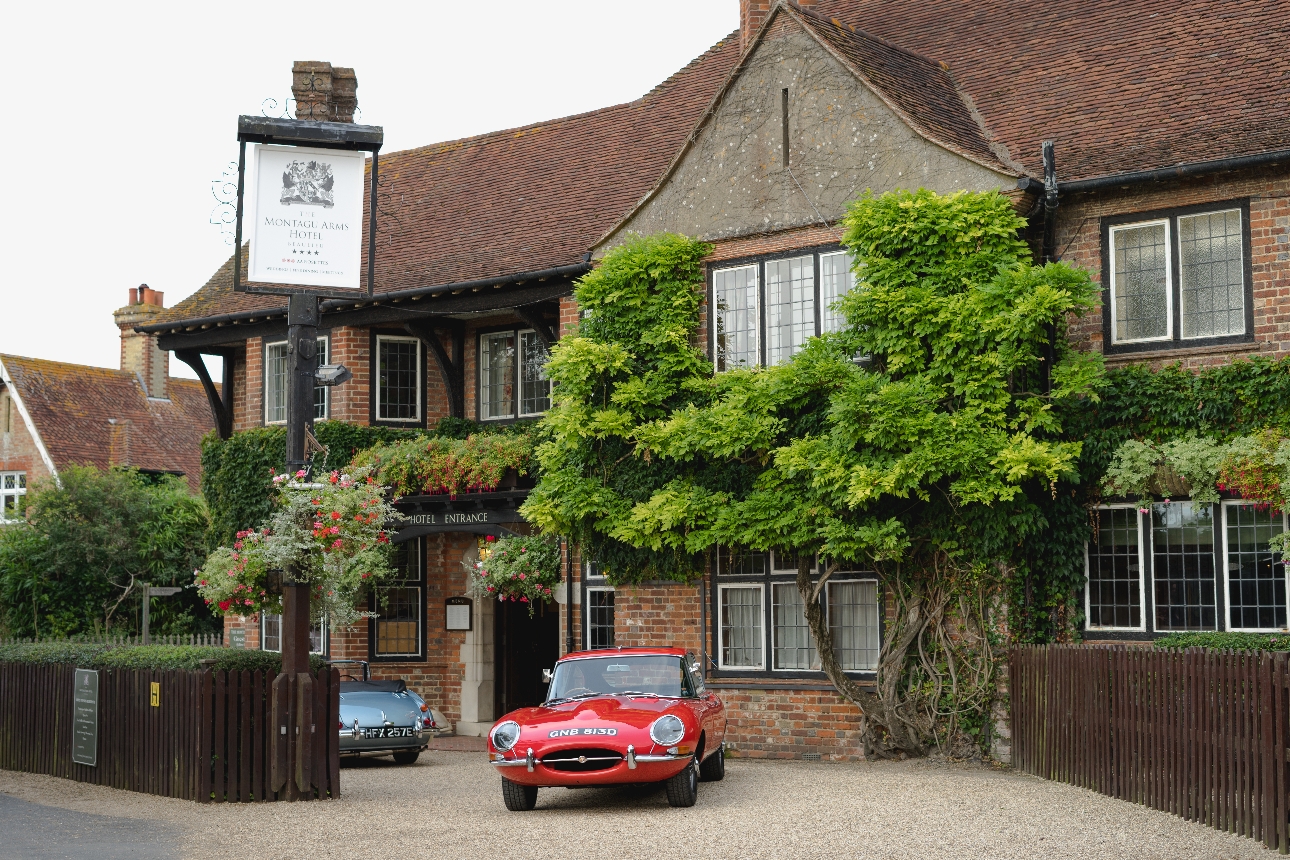 quaint country house manor house with two vintage cars outside