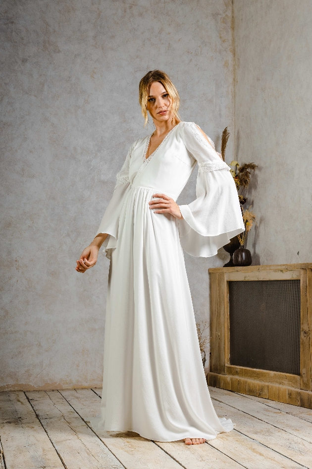 model in flowing gown with long sleeves