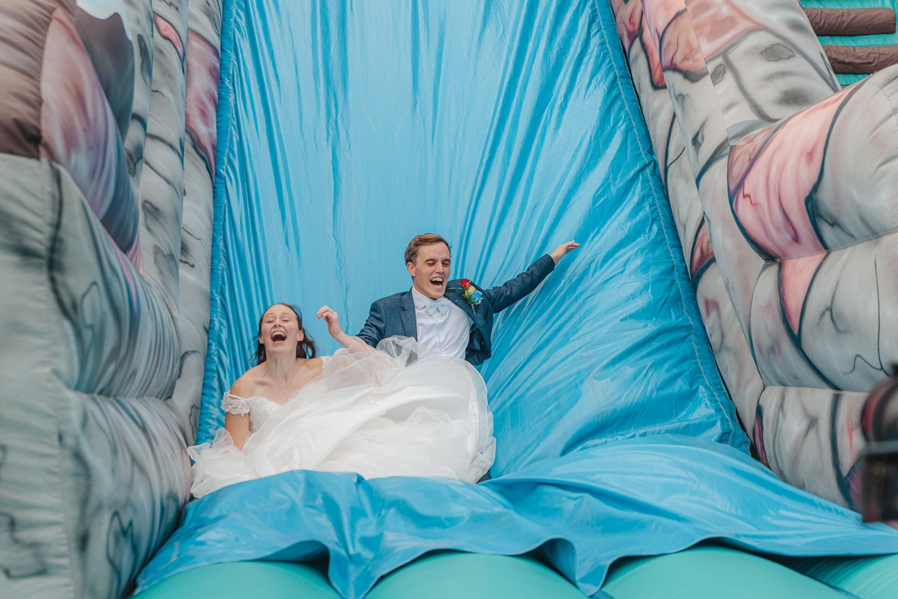 bride and groom coming down an inflatable slide
