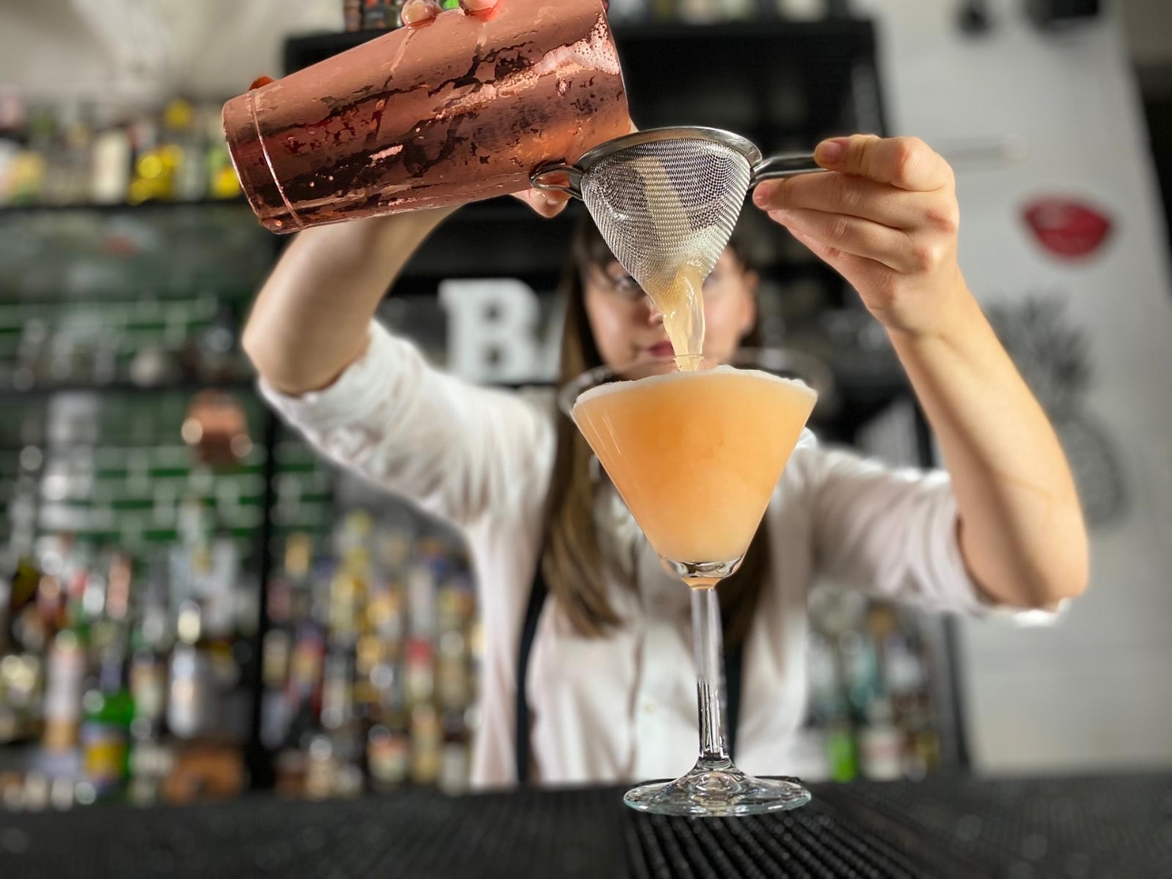 bartender pouring a cocktail
