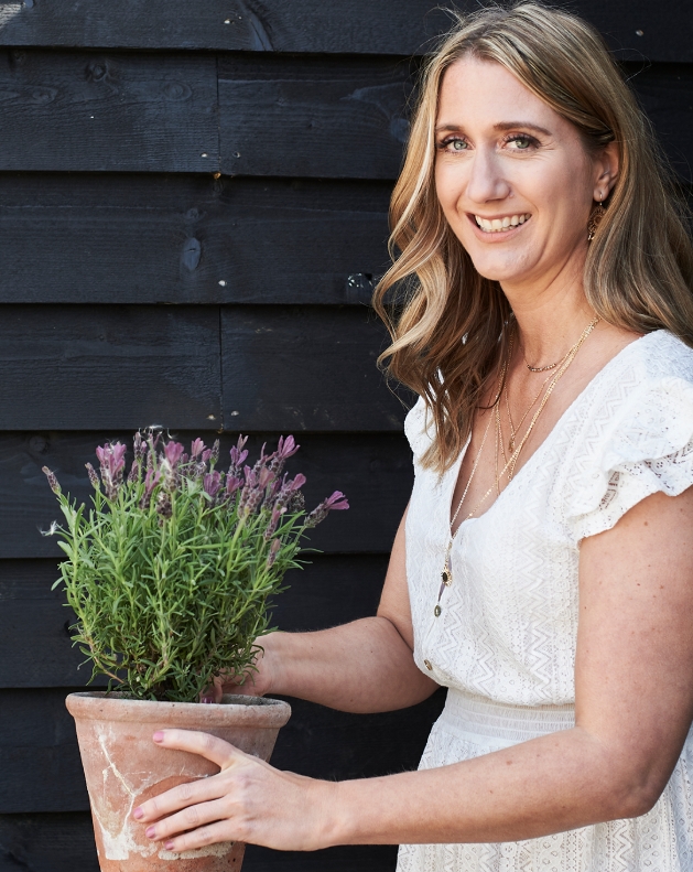 Woman in a white dress holding a potted plant