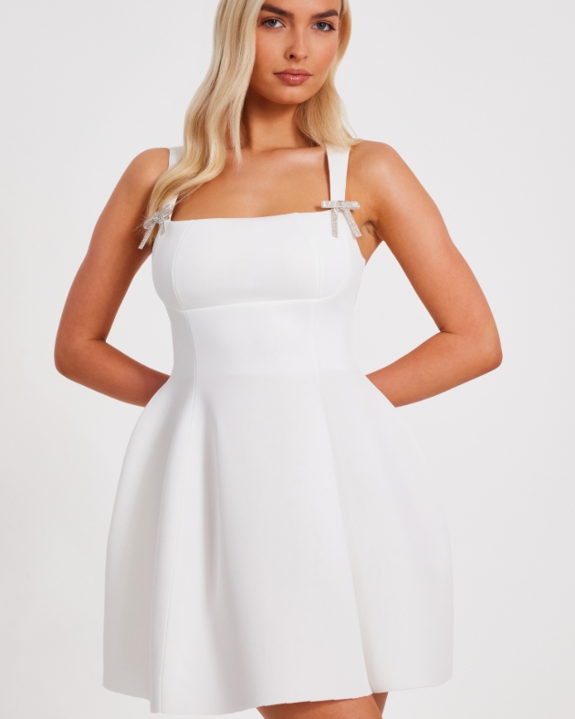 woman in short white dress with diamanté bows 