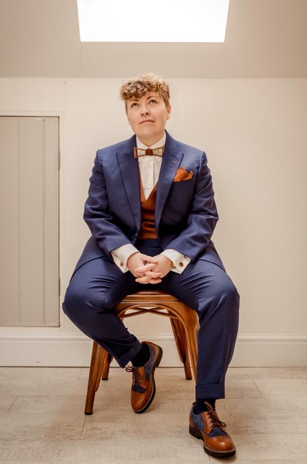 woman in suit sat on chair 