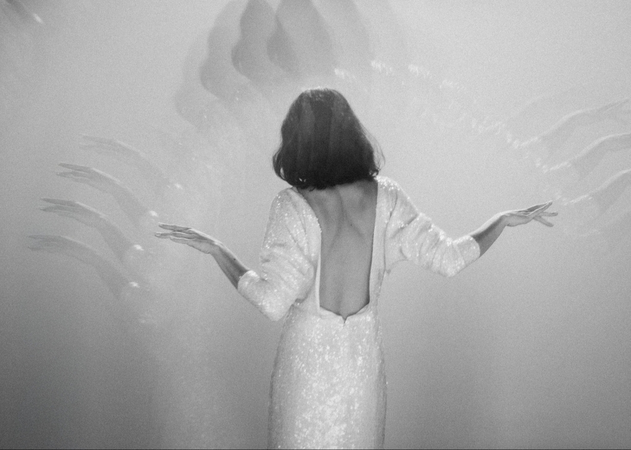 back image of a model in a white sequin dress with sleeves