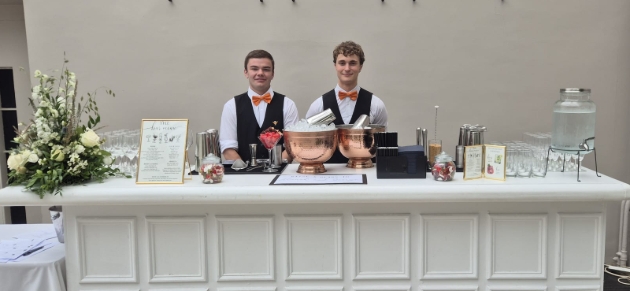 two waiters behind a cocktail bar